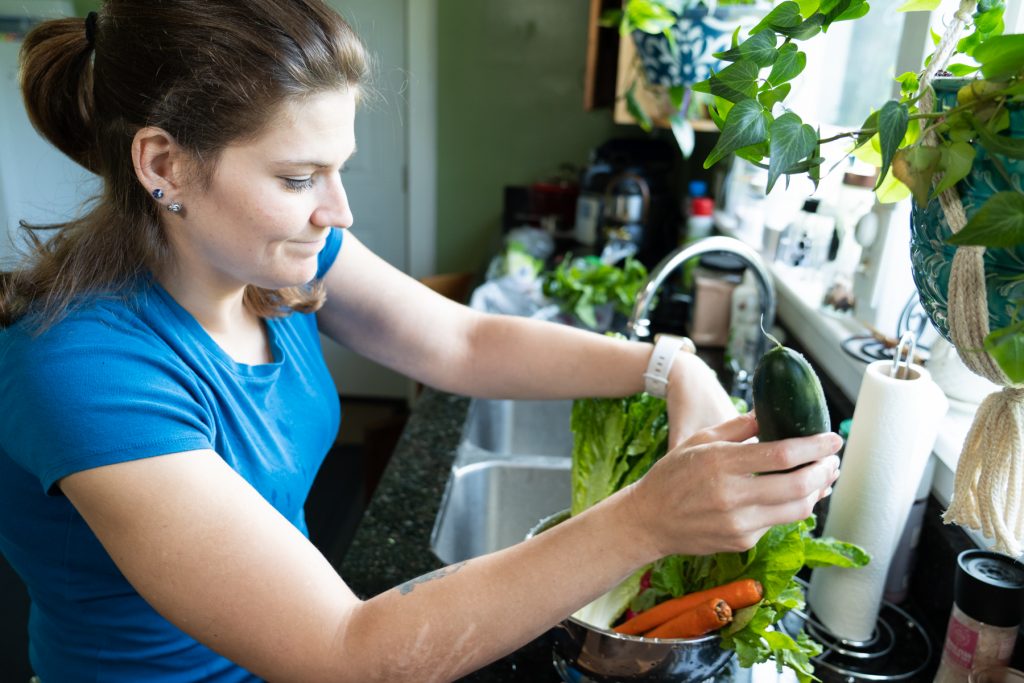 Woman in a blue shirt holding a cucumber